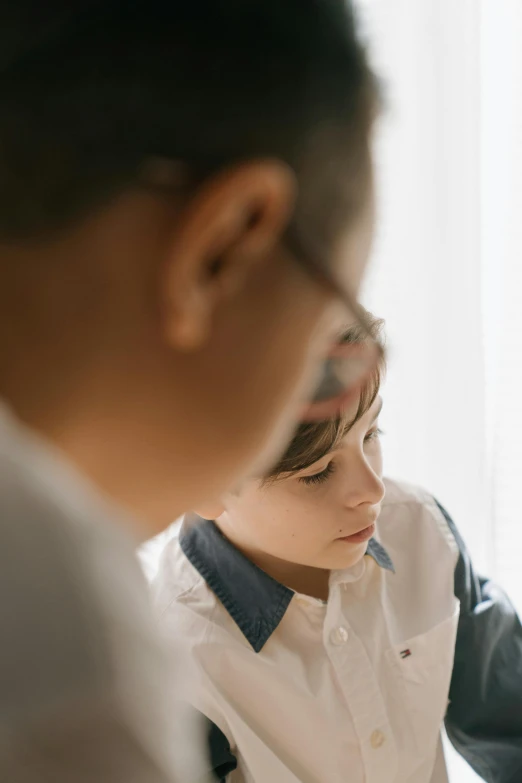 a couple of kids that are sitting at a table, by Nina Hamnett, trending on unsplash, process art, close - up profile face, soft morning light, wearing a patch over one eye, studying