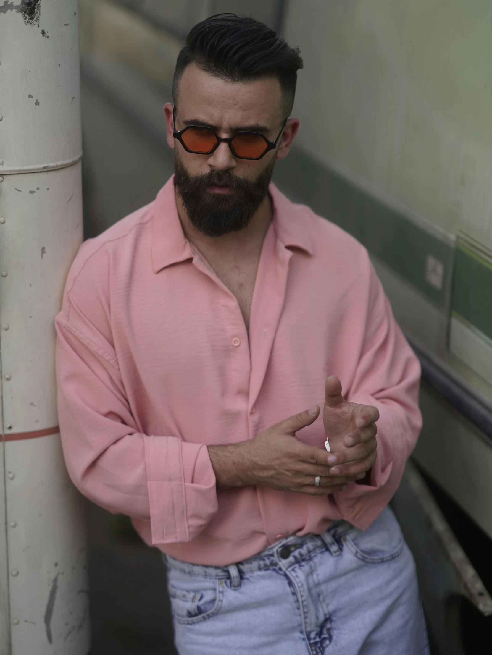 a man with a pink shirt is smoking and holding soing