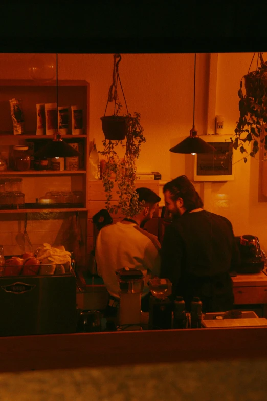 three people in a kitchen next to a counter