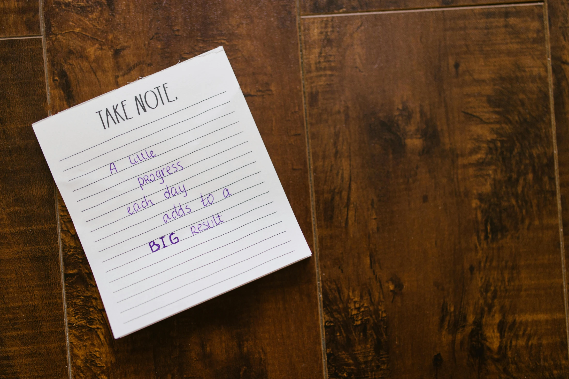 a note sitting on top of a wooden floor, by Nina Hamnett, pexels contest winner, gigantic scale, sharpie, bingus, take