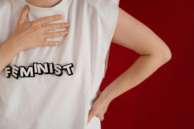 a woman's arm is in her t - shirt with the word feminist on it