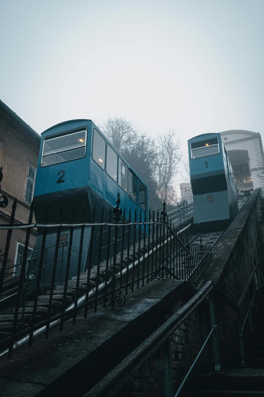 blue train cars going down the rails to other tracks