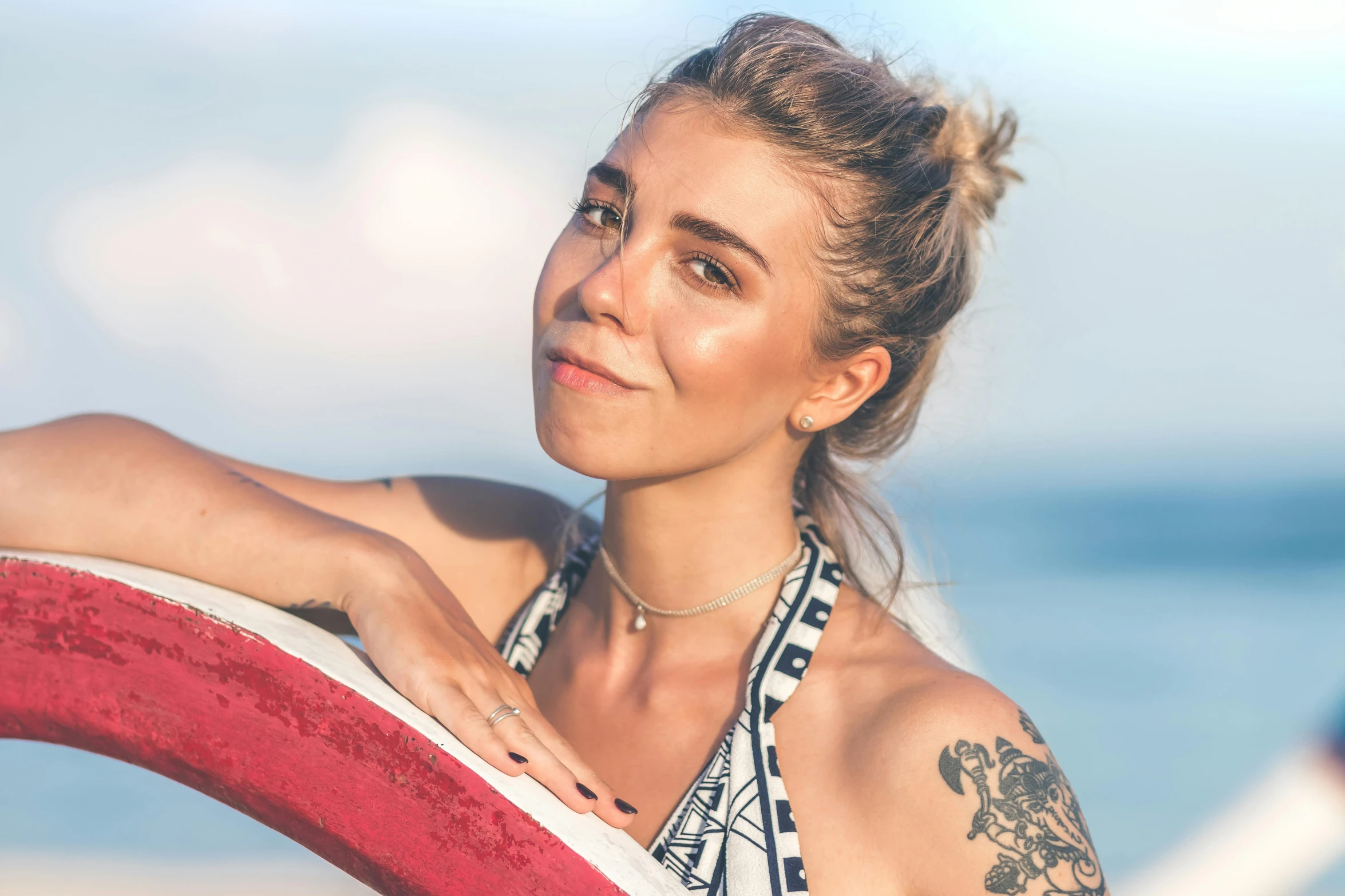 a woman standing on top of a beach holding a surfboard, septum piercing, headshot profile picture, charli bowater and artgeem, topknot