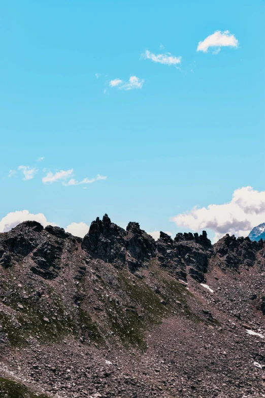 a mountain in the foreground with clouds in the sky