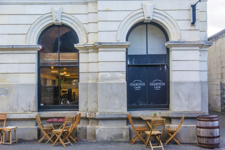 a couple of wooden chairs sitting in front of a building, inspired by Richmond Barthé, renaissance, aussie baristas, wunderkammer, lovers eat, profile image