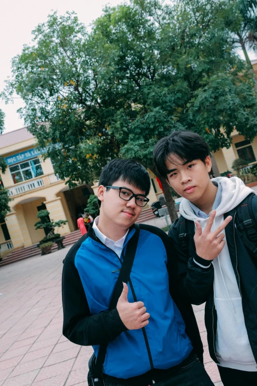 a couple of young men standing next to each other, a picture, inspired by Gang Hui-an, unsplash, realism, low quality photo, private school, squishy, dang my linh