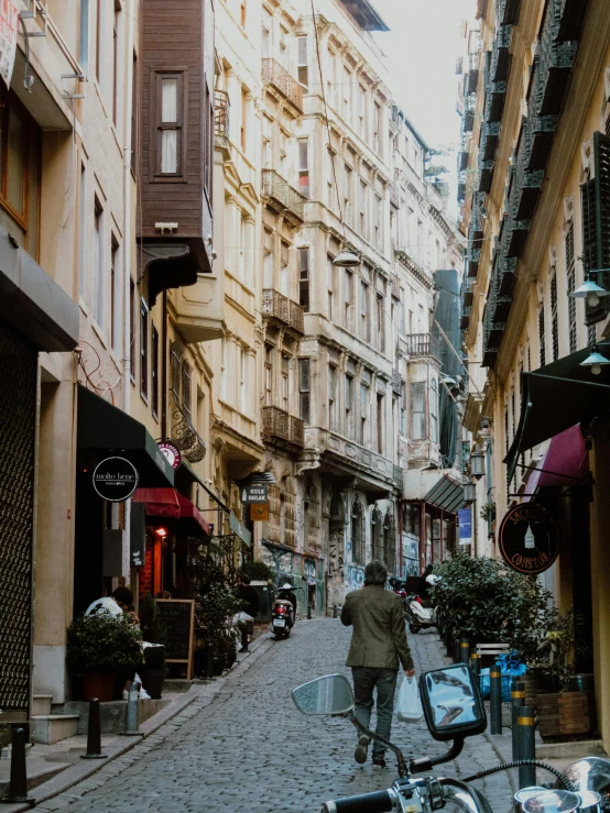 a man walking down a cobblestone sidewalk holding an umbrella