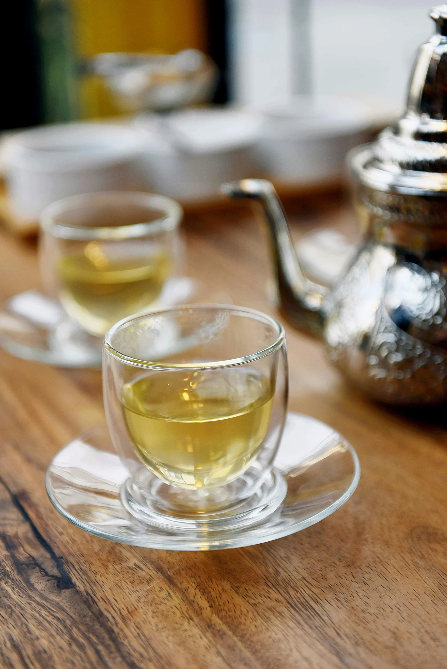 a tea pot sitting on top of a wooden table, hurufiyya, silver small glasses, photograph credit: ap, square, food