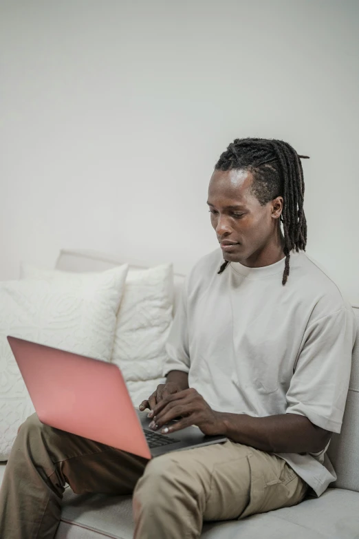 a man sitting on a couch using a laptop, by Carey Morris, pexels contest winner, afrofuturism, mid long hair, lgbt, official screenshot, excel running on the computer