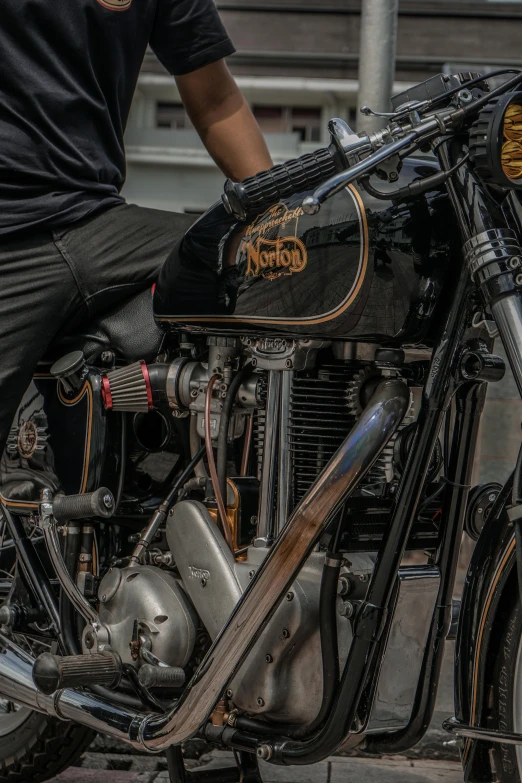 a man that is sitting on a motorcycle, pexels contest winner, photorealism, intricate mechanical details, restomod, black, golden engines