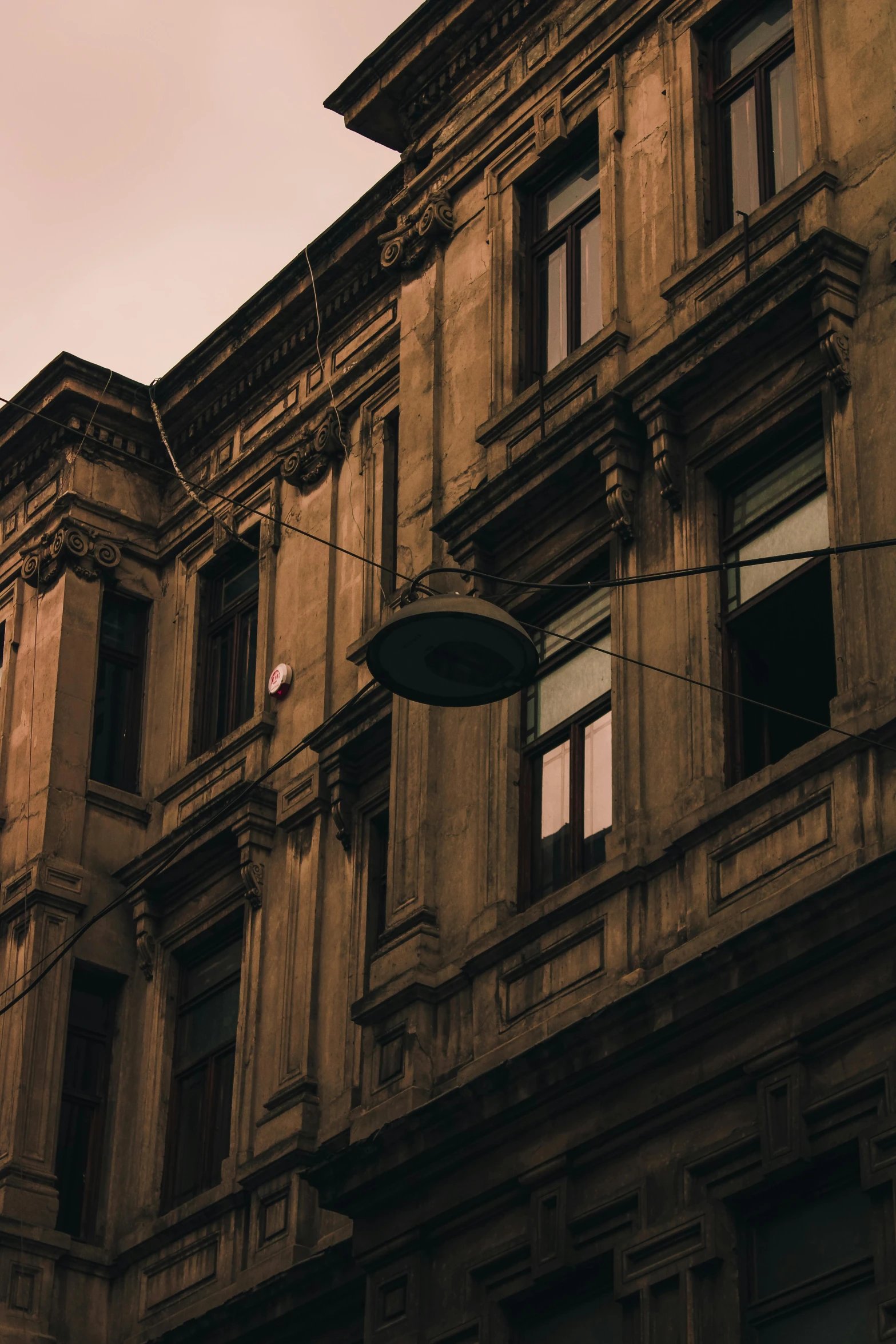 a clock that is on the side of a building, a photo, inspired by Elsa Bleda, pexels contest winner, renaissance, beige and dark atmosphere, nepali architecture buildings, late summer evening, wires hanging across windows
