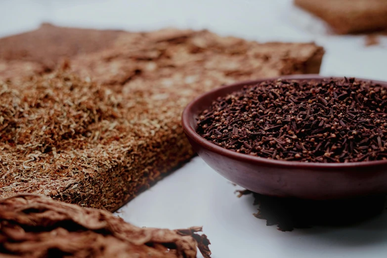 a close up of a bowl of food on a table, an album cover, trending on pexels, hurufiyya, dried herbs, bark for skin, brown body, lacquerware