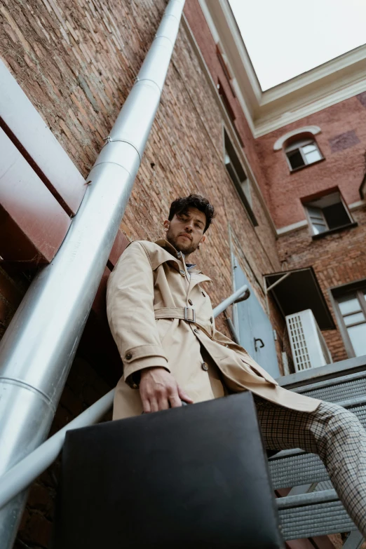 a man in a trench coat holding a briefcase, pexels contest winner, renaissance, on rooftop, tom of finland style, young spanish man, light brown trenchcoat