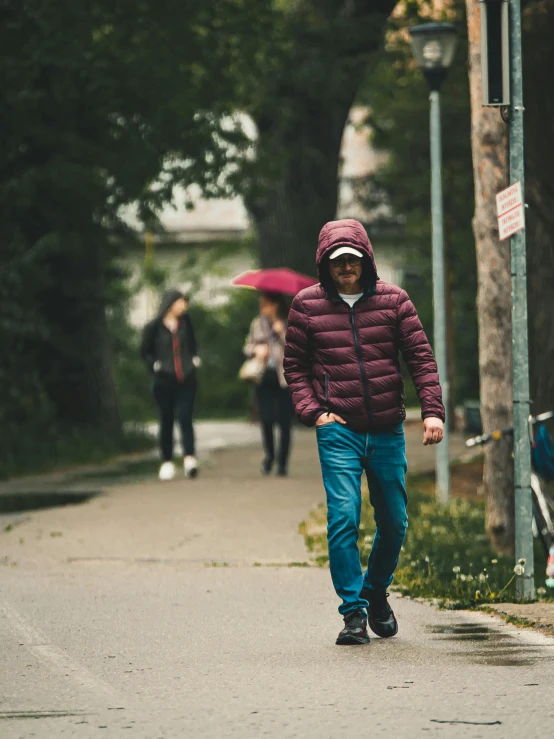 a man wearing a jacket and holding an umbrella