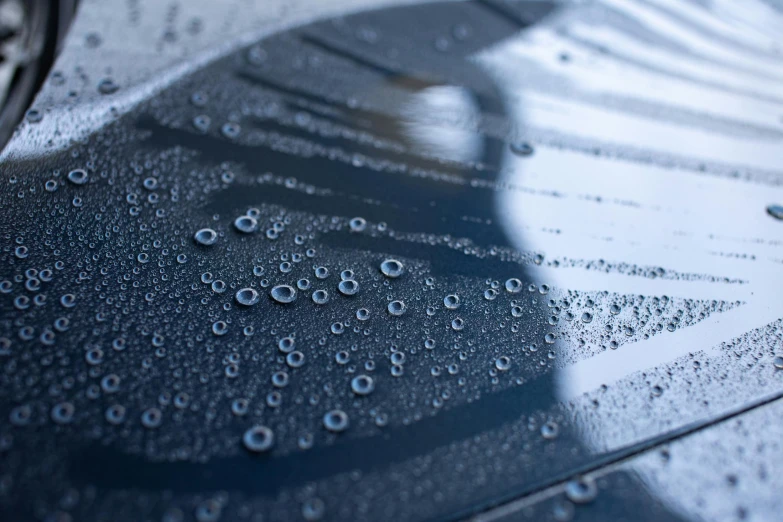 a close up of water droplets on the hood of a car, an album cover, inspired by Lucio Fontana, unsplash, plasticien, shades of blue and grey, etched relief, vinyl material, high details photo