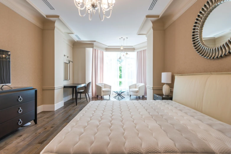 the large bedroom has two chandeliers, two lamps and a bed with white bedspread