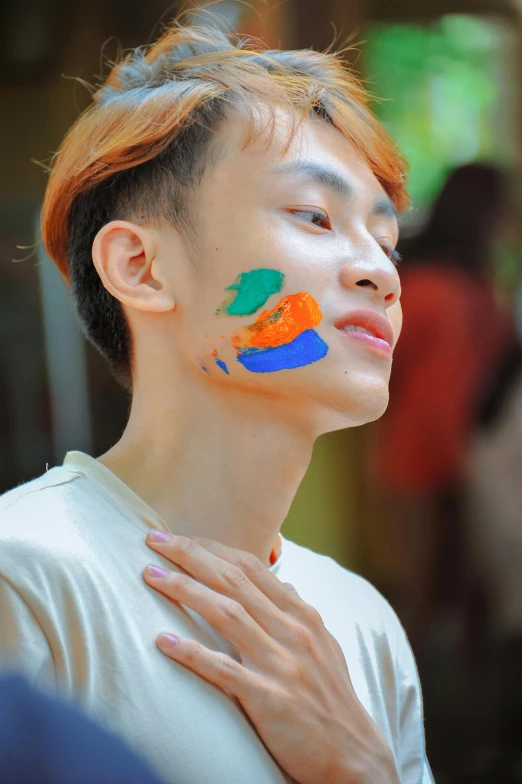 a close up of a person with paint on their face, an album cover, inspired by Pan Tianshou, trending on pexels, gay, indonesia, cute boy, fair skinned