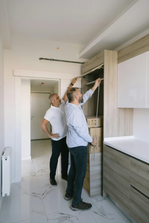 a couple of men standing next to each other in a kitchen, by Alexander Fedosav, unsplash, superflat, under construction, exiting from a wardrobe, gif, high quality picture