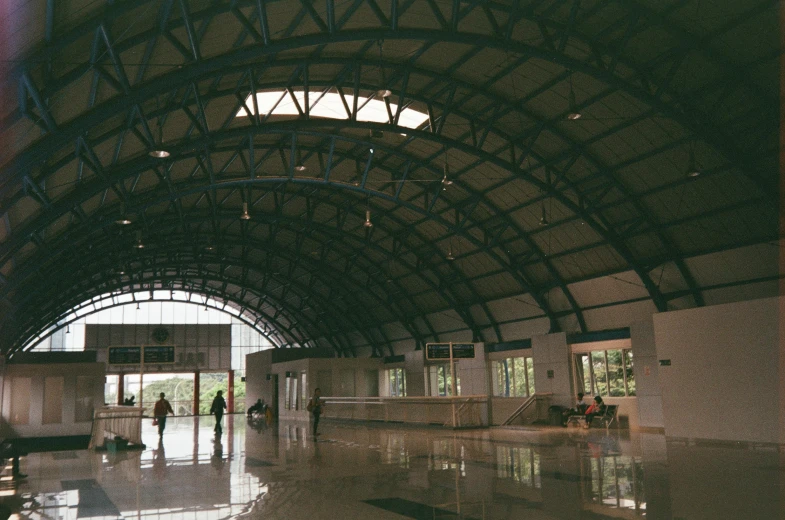 a couple of people that are standing in a building, unsplash, bengal school of art, airport, truss building, 1999 photograph, canopies