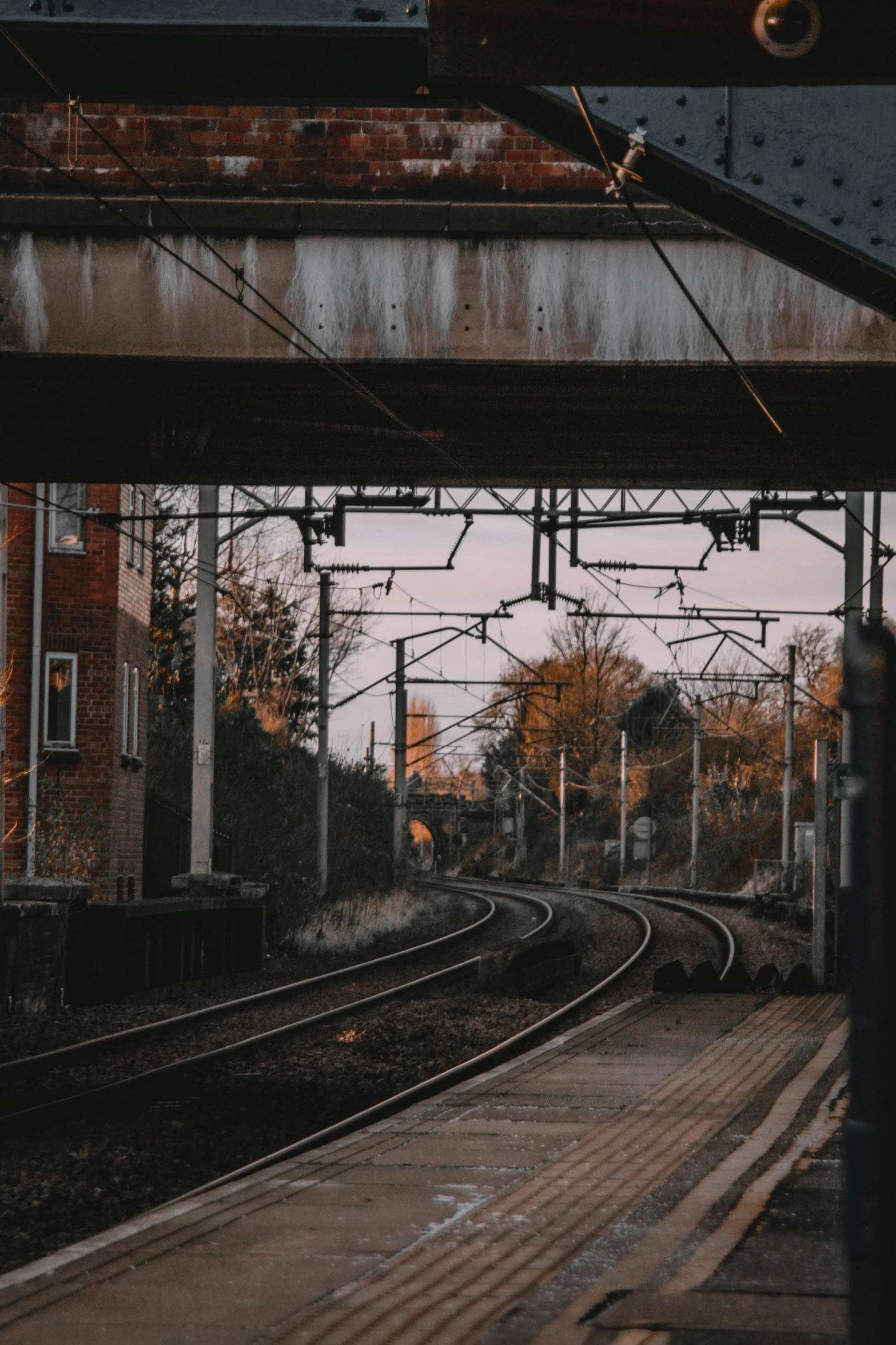 a train traveling down train tracks next to a train station, a picture, pexels contest winner, low quality photo, looking out, in a suburb, random circular platforms