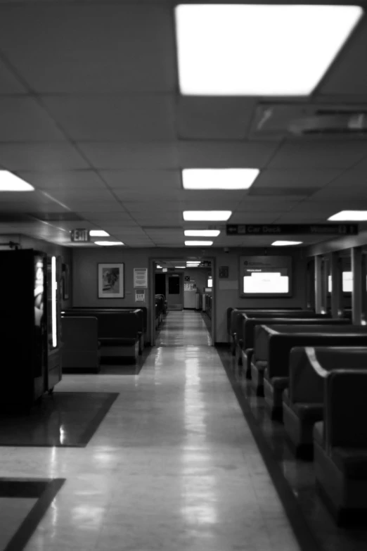 a black and white photo of a long hallway, a black and white photo, flickr, interior of staten island ferry, doctors office, late night, desolate :: long shot