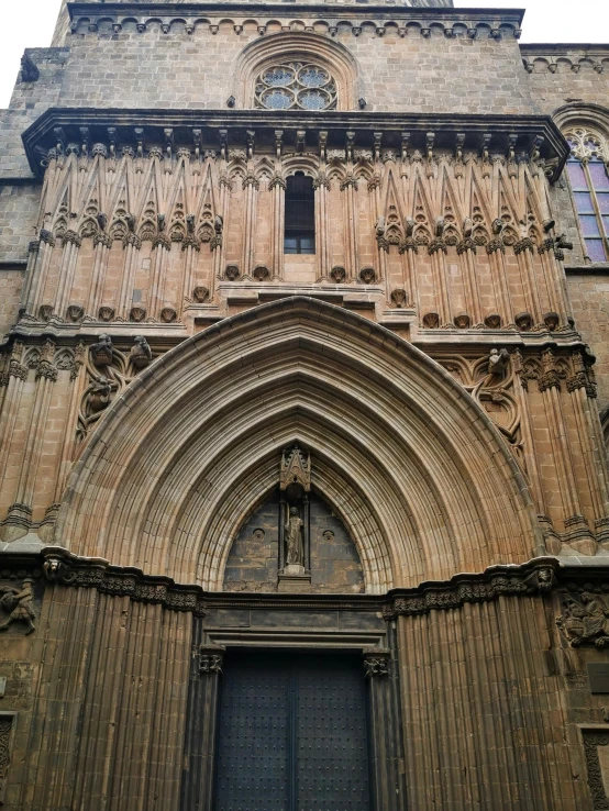 a tall building with a clock on the front of it, inspired by Modest Urgell, romanesque, symmetrical doorway, inside cathedral, gothic quarter, golden gates