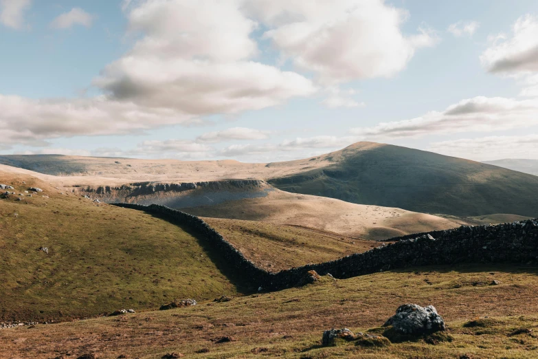 there are several hills covered with grass and rocks