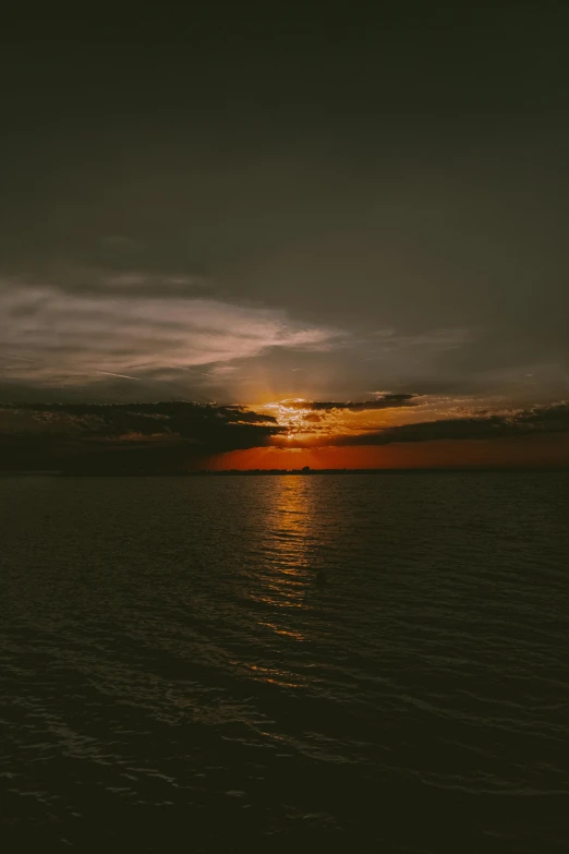 the sun is setting over a body of water, pexels contest winner, romanticism, overcast skies, low quality photo