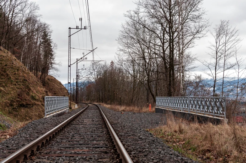 a picture of railroad tracks going along the side of a hill