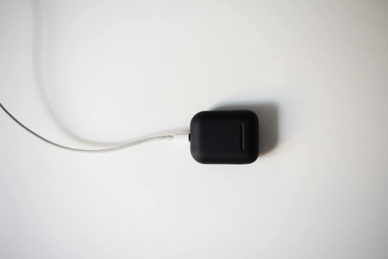 a computer mouse sitting on top of a white surface, by Niels Lergaard, minimalism, airpods, square, black, cable