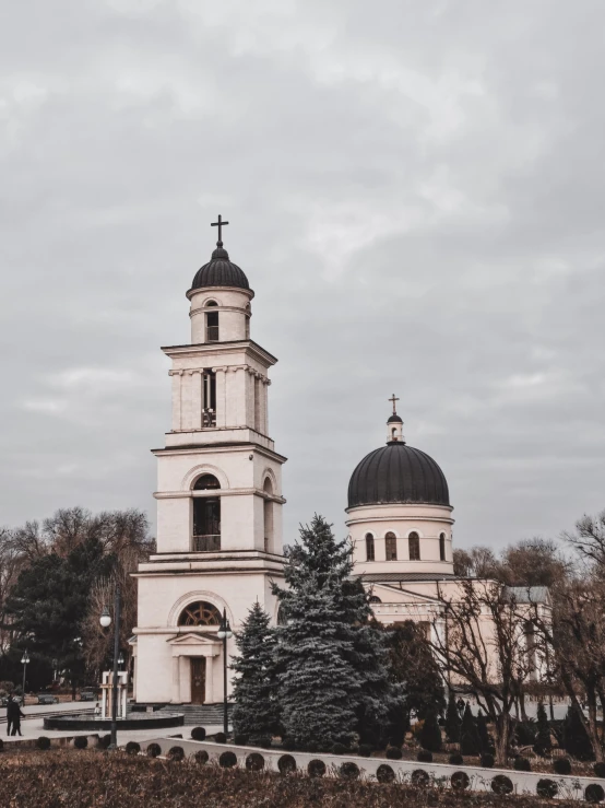 a large white building with a clock tower, a photo, by Emma Andijewska, pexels contest winner, orthodox saint, two towers, 👰 🏇 ❌ 🍃, slight overcast weather