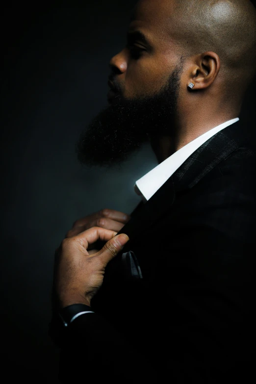 a man in a suit adjusting his tie, inspired by Paul Georges, pexels contest winner, renaissance, black curly beard, glamor profile pose, ( ( dark skin ) ), album cover