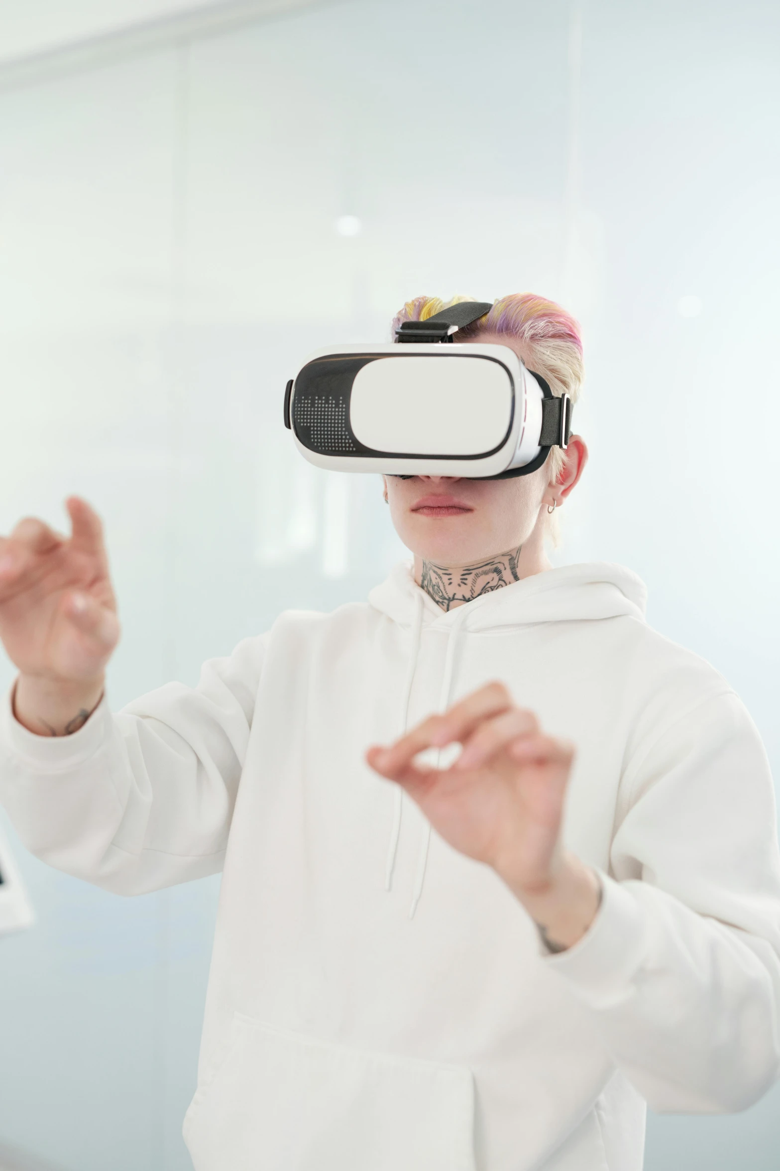 a man in a white hoodie wearing a virtual reality headset, trending on pexels, holography, cai xukun, hands up, looking towards camera, wearing goggles