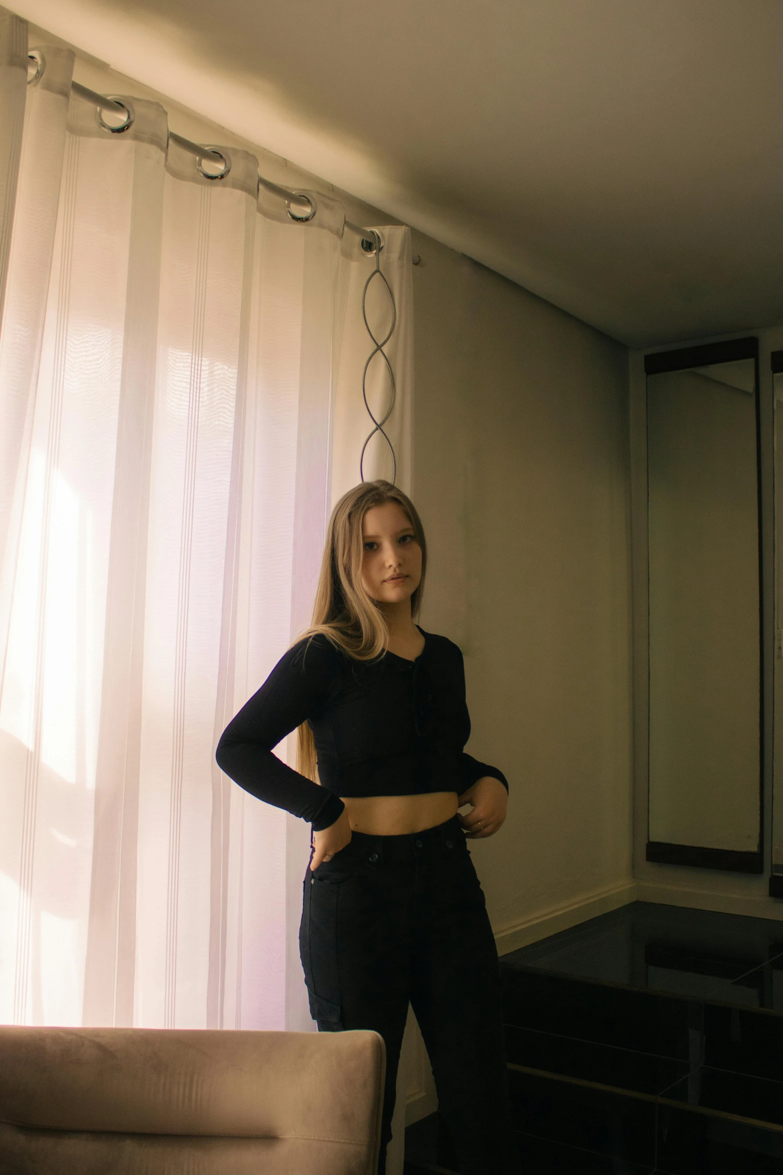 young woman standing in the corner looking in the mirror