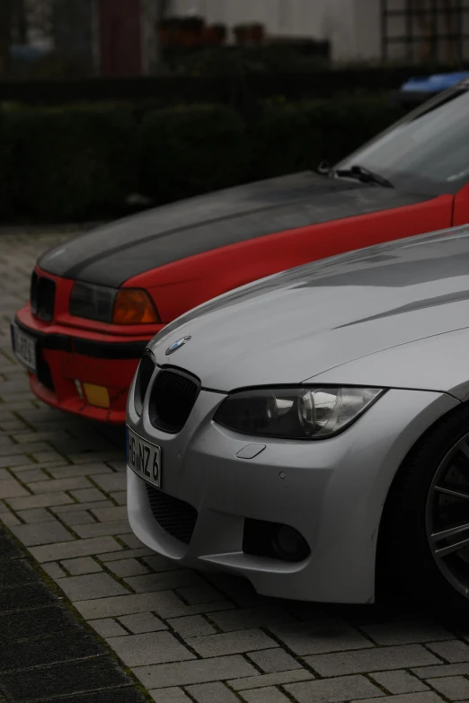 two bmw cars parked on the side of the road