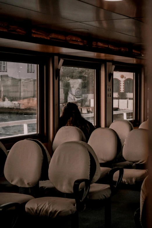 a person sitting in a bus looking out the window, pexels contest winner, tonalism, on a boat, in a row, sitting on a chair, you can see all the passageways