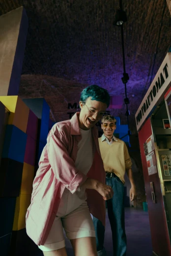 a couple of people standing next to a vending machine, an album cover, trending on pexels, antipodeans, in a ball pit, non binary model, in the museum, with teal clothes