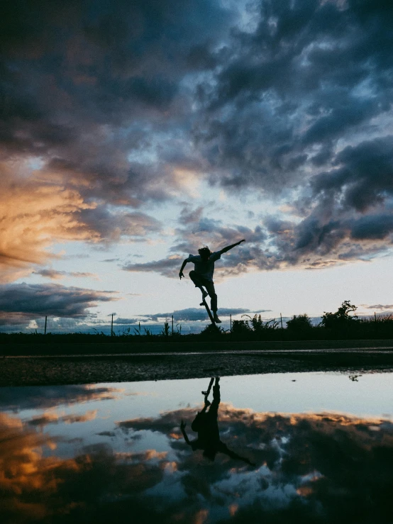 a man flying through the air while riding a skateboard, a picture, by Jacob Burck, unsplash contest winner, happening, sunset with cloudy skies, reflection puddles, in a jumping float pose, ((sunset))