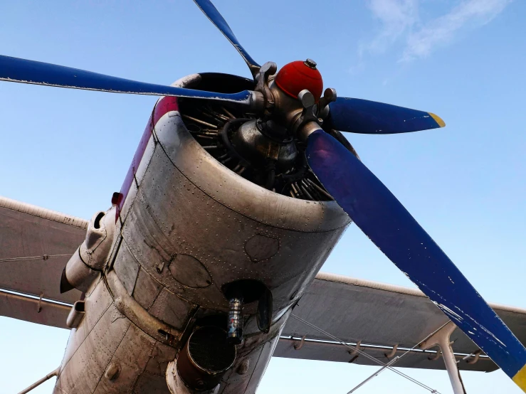 a close up of a propeller on a plane, by David Simpson, pexels contest winner, photorealism, war thunder game, large blue engines, looking upward, full body close-up shot