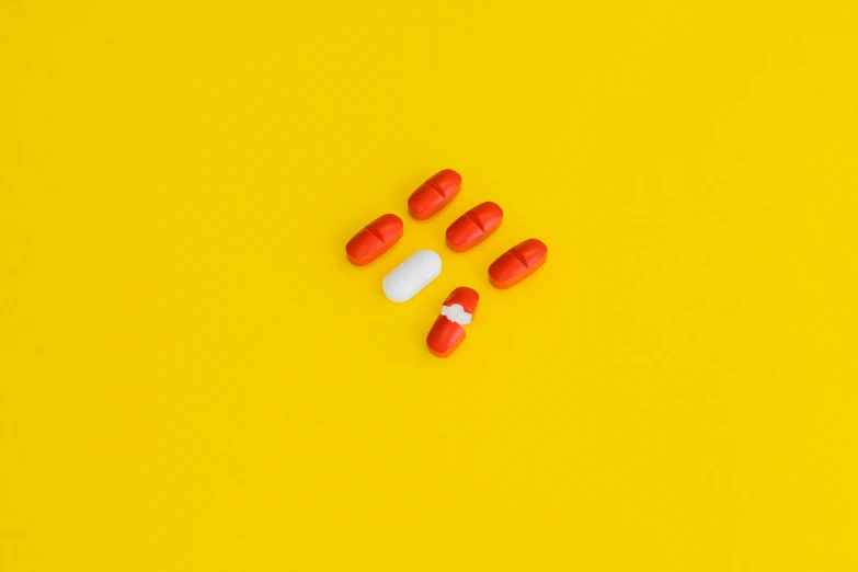 pills and capsules on a yellow background, by Adam Marczyński, antipodeans, red and white color scheme, color ( sony a 7 r iv, ffffound, minimalist photorealist