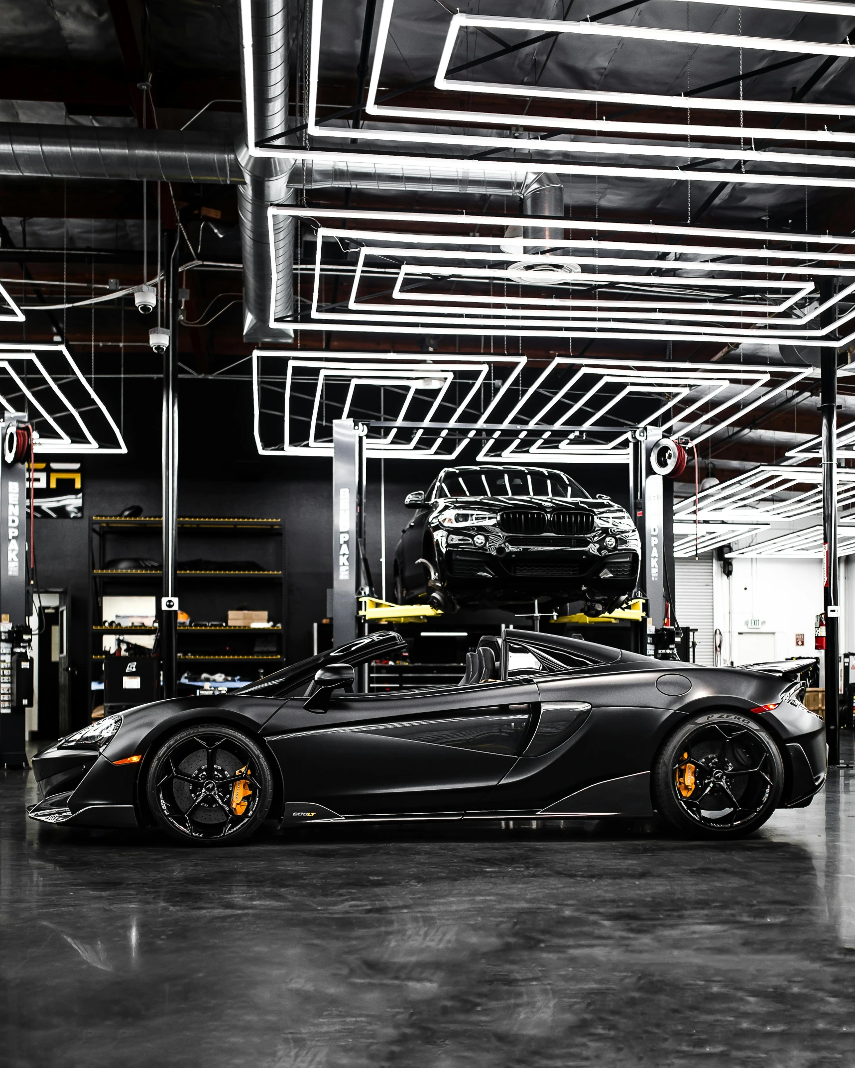 a black sports car parked in a garage, by Anthony Devas, pexels contest winner, mclaren, thicc build, convertible, featuring wires