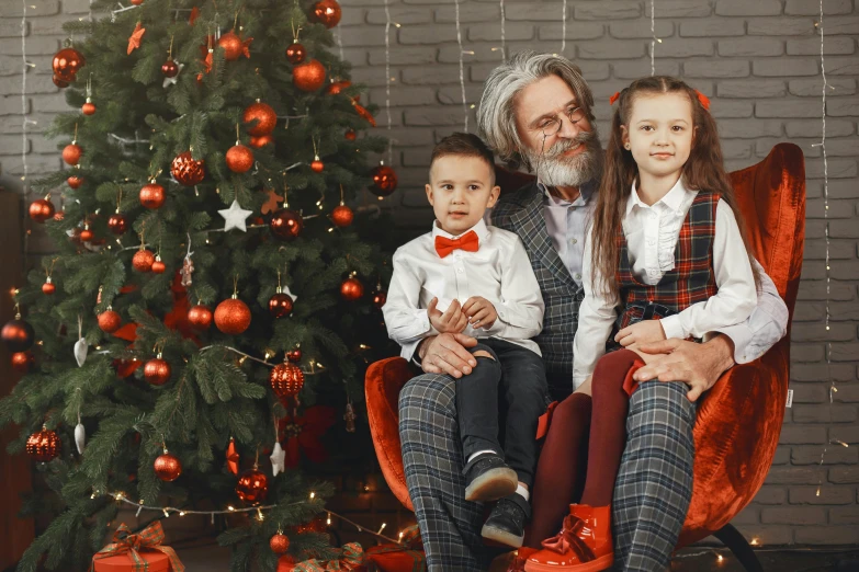 a man and his two s are in front of a christmas tree