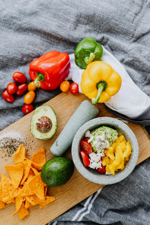 a wooden cutting board topped with chips and vegetables, a still life, inspired by Ceferí Olivé, pexels contest winner, avocado and cheddar, bowl of fruit, detailed product image, rice