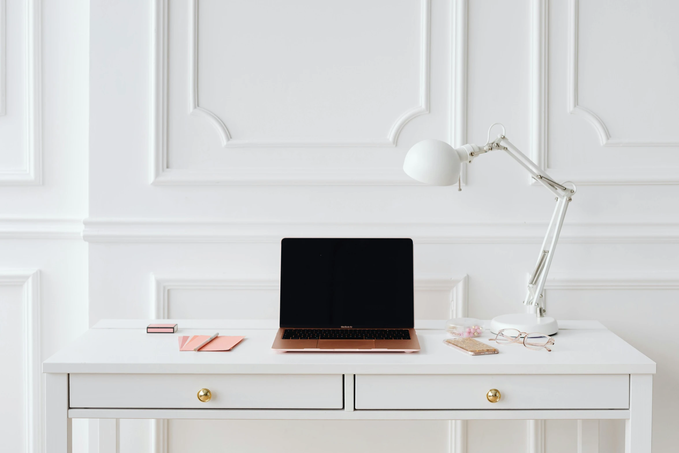 a laptop computer sitting on top of a white desk, by Julia Pishtar, trending on pexels, intricate copper details, white room, rectangle, low - lighting