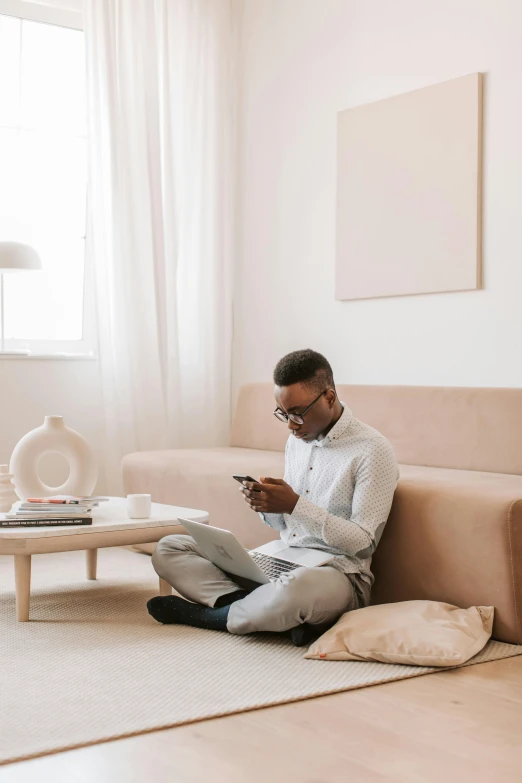 a man sitting on the floor using a cell phone, trending on pexels, couch desk, an all white human, black man, pastel'