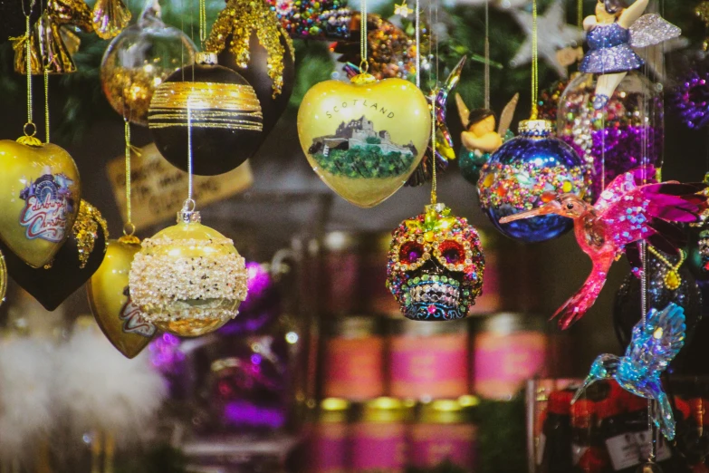 a bunch of ornaments hanging from a tree, by Julia Pishtar, pexels, maximalism, inside an old magical sweet shop, tilt shift glass background, intricate skeletal decorations, green magenta and gold