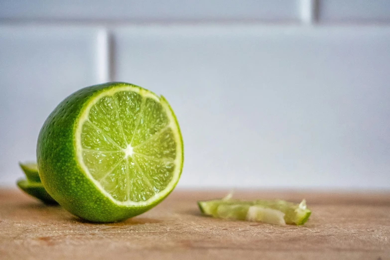 a lime cut in half on a cutting board, inspired by Grillo Demo, pexels, at the counter, crisp detail, award - winning crisp details ”, 🍸🍋