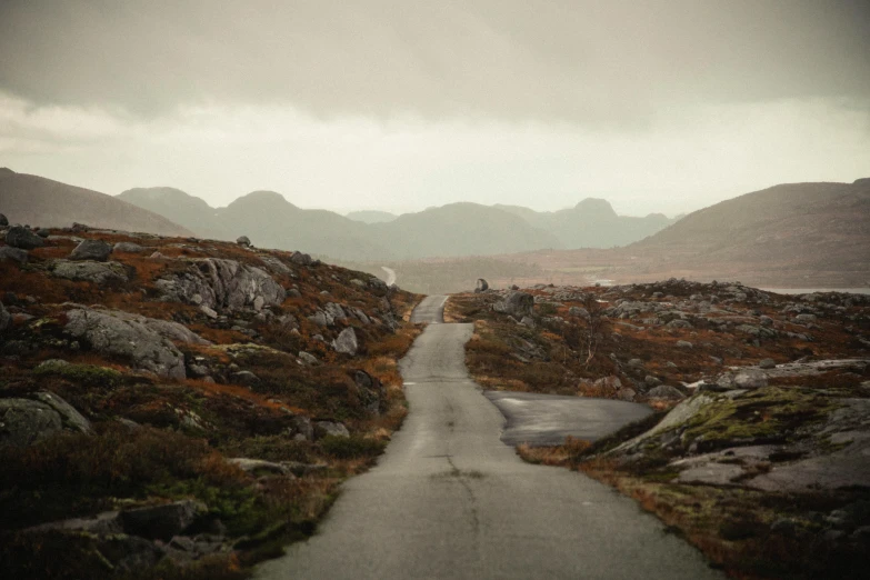 an image of a road with some mountains in the background