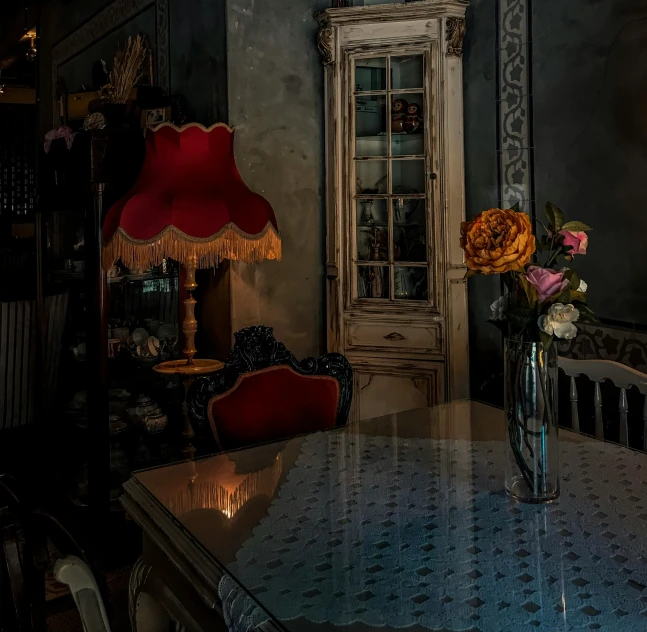 flowers in vase on table with a cabinet behind