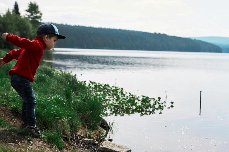 a young boy throwing a frisbee next to a body of water, by Jaakko Mattila, pexels contest winner, hurufiyya, forest with lake, pensive, where a large, youtube thumbnail